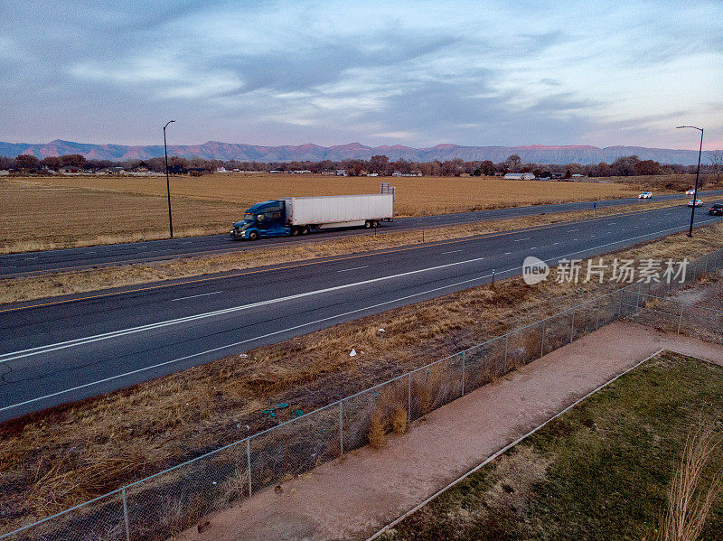 长途半挂卡车在四车道的高速公路上加速运送货物