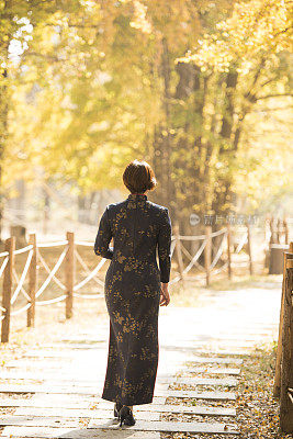 秋天走在树林里的中国妇女穿着传统的中国服装