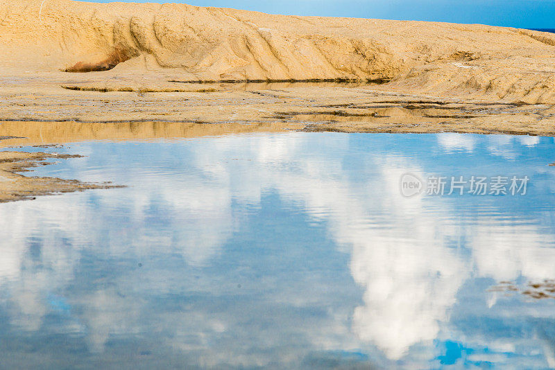 云朵倒映在砂岩山上的一个大水坑里——水镜