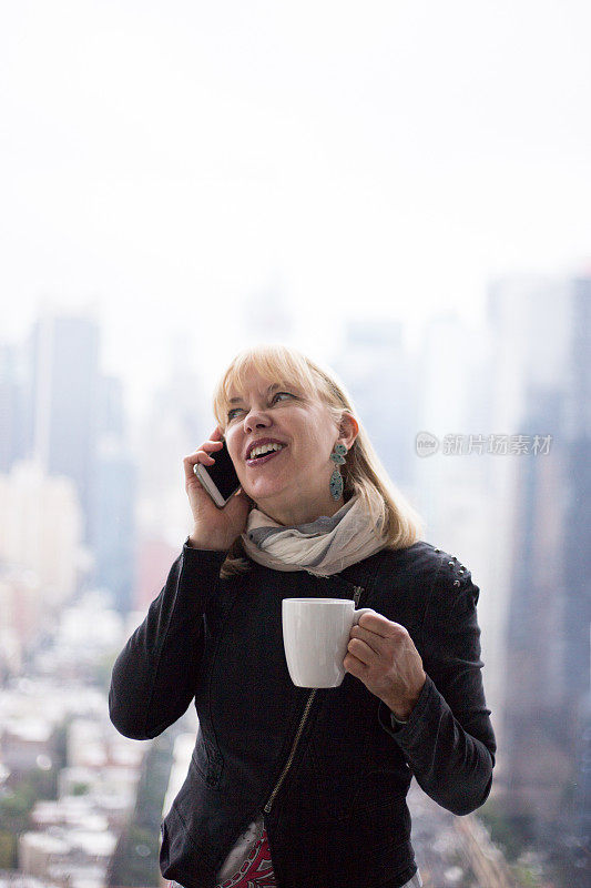 在曼哈顿办公室与城市天际线通电话的女人
