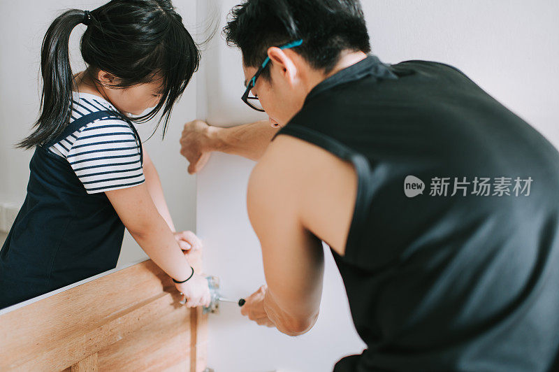 一个亚裔华人家庭搬家，女儿帮父亲组装床架