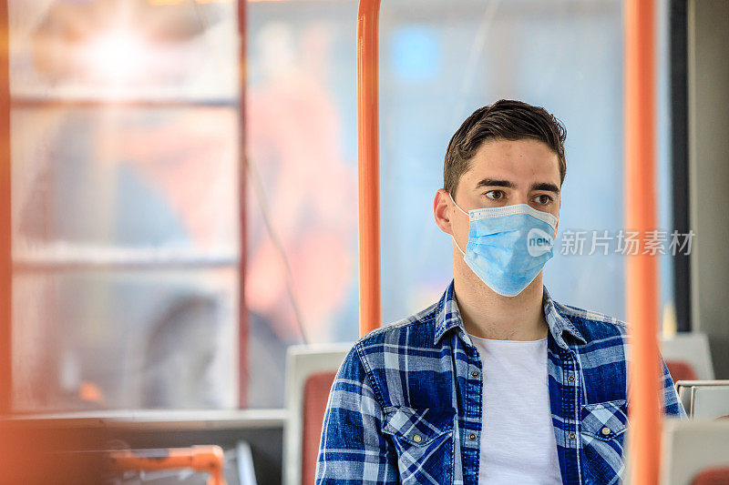 在公共汽车运输中戴着防护面罩的焦虑男子。