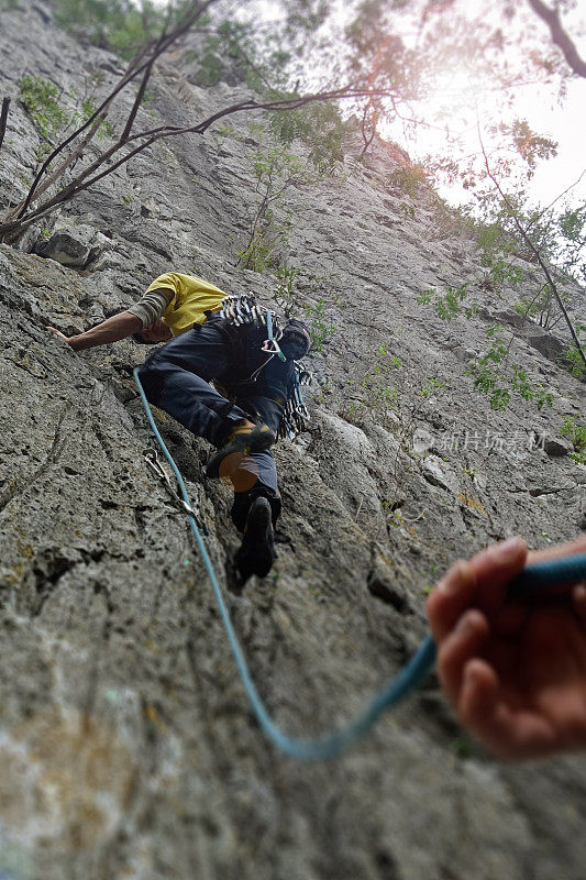一名年轻人正在墨西哥的波特雷罗·德奇科登山，一名男子用绳子把他绑住