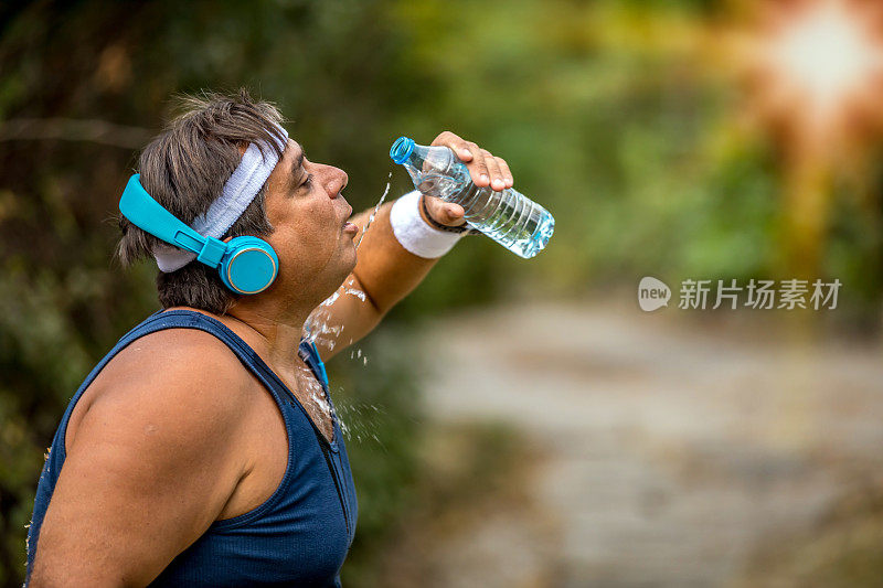 喝水的时间到了。一个在剧烈运动后大口呼吸和喝氨基酸的超重男子