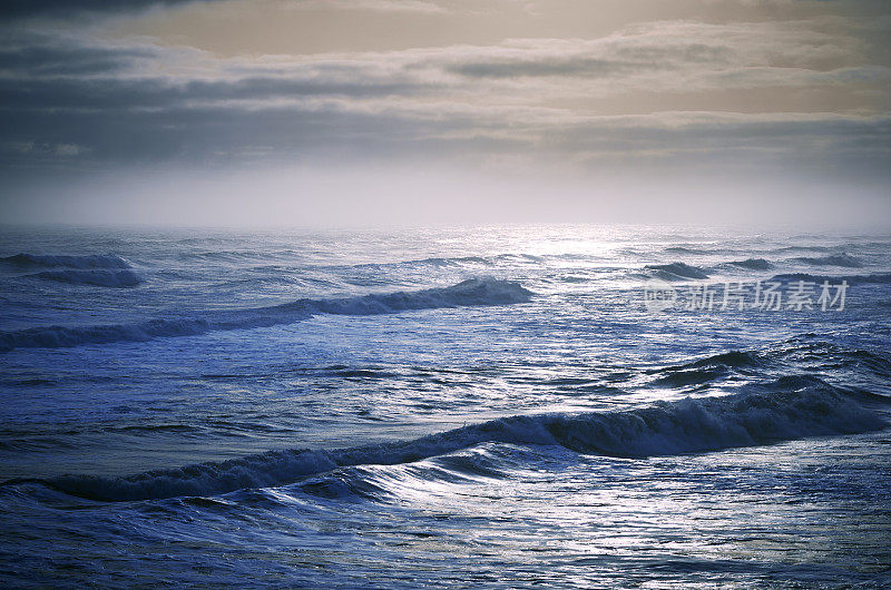 日落在蓝色风暴波浪闪亮的海