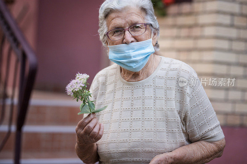 在户外戴防护口罩的老年妇女