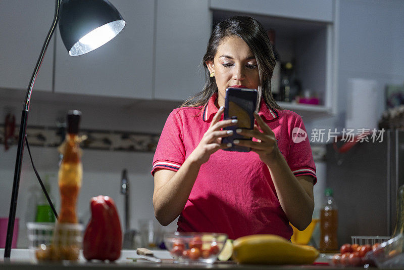 拉丁妇女在家做饭用手机