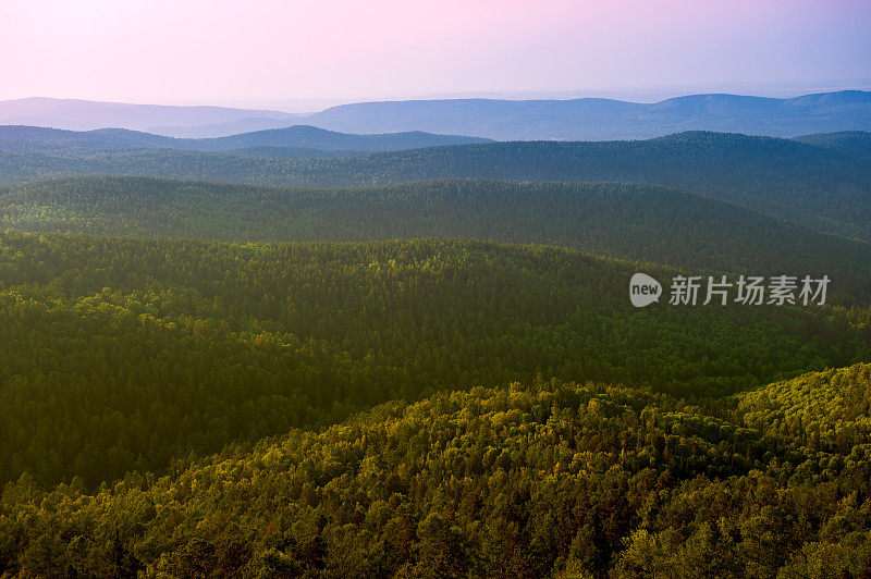 针叶林。西伯利亚。傍晚的山景和日落的天空。