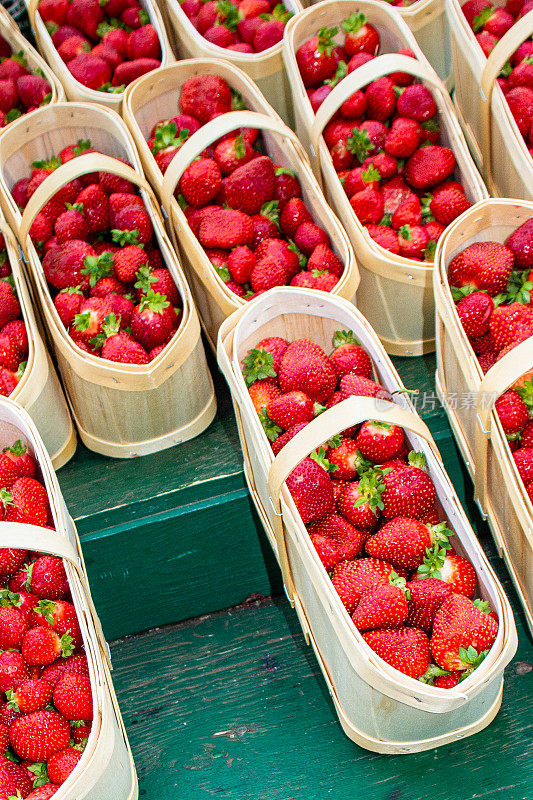 农贸市场里装在木篮子里的新鲜草莓。