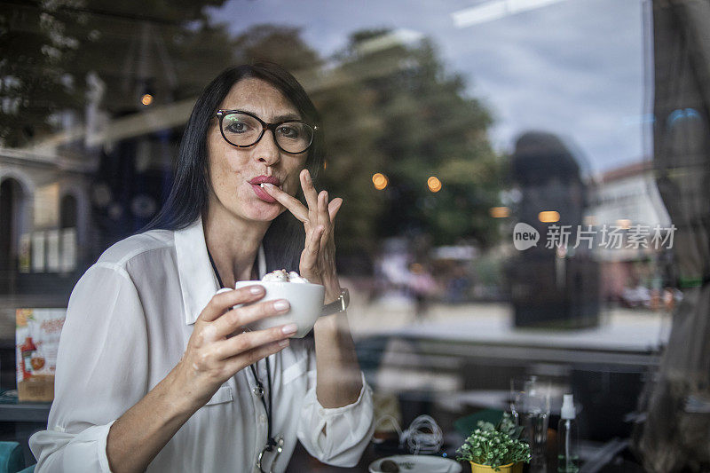 一个女人，一个现代成熟的黑发女士，正在一个咖啡馆喝咖啡-相当漂亮的黑发女士在一个咖啡店工作