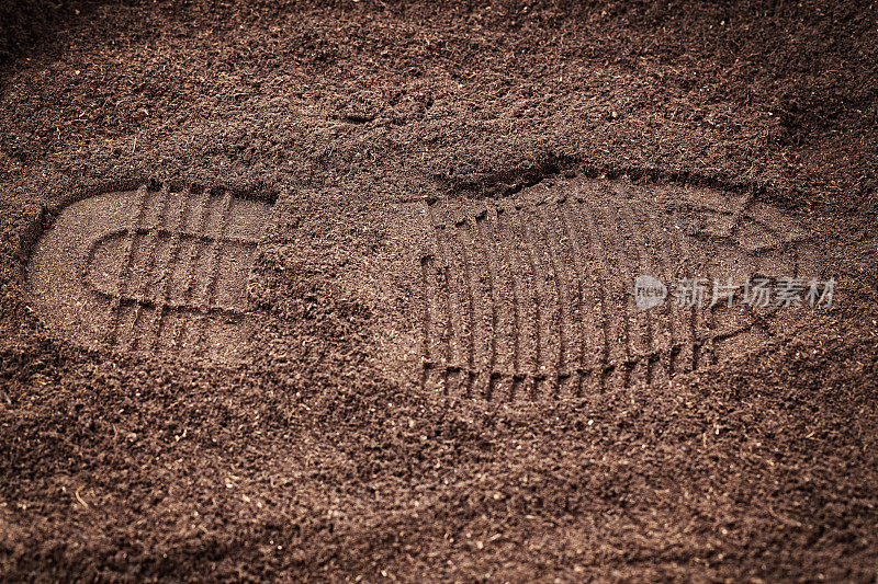 鞋印在泥土上。刑事库存图片。
