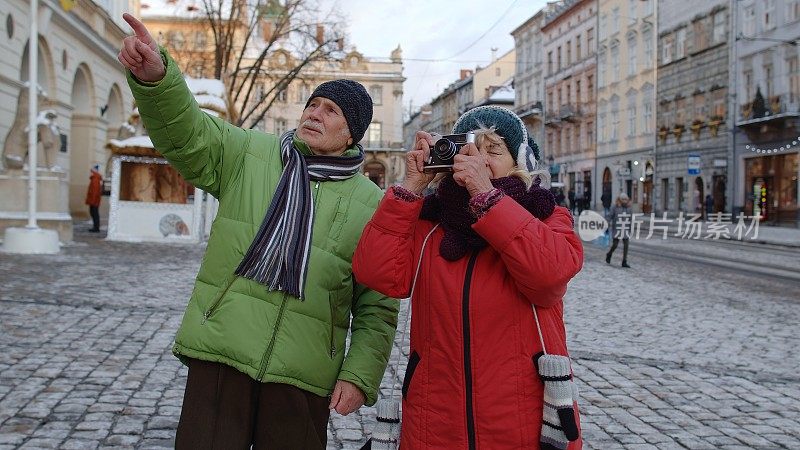 老两口游客奶奶爷爷在冬城用复古相机拍照
