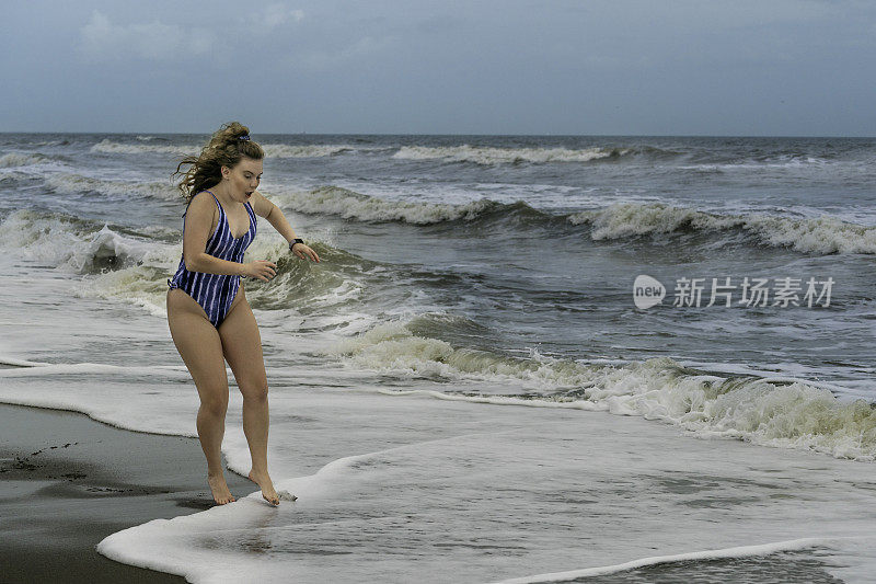 漂亮的雌性在冬天造访冰冷的海水