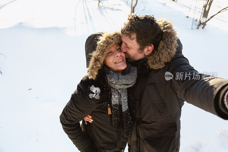 幸福的成熟夫妇在雪中自拍
