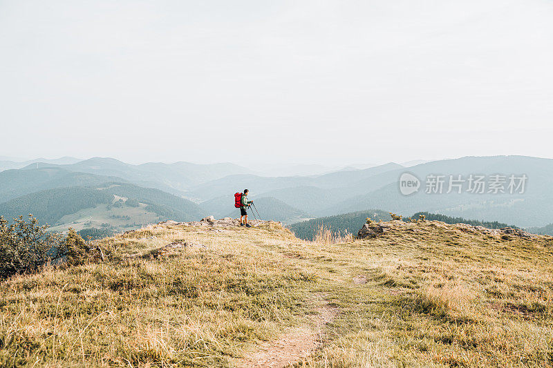 徒步旅行者在长满草的山脊上放松的观点