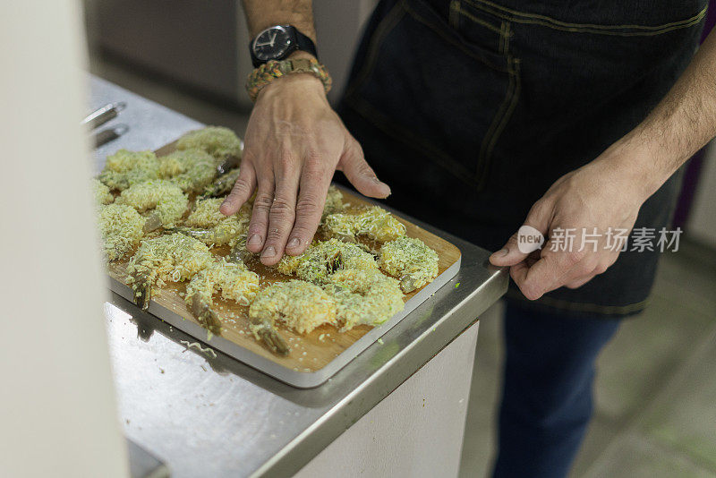 一名男子正在为他为客人准备的秘密晚餐准备零食