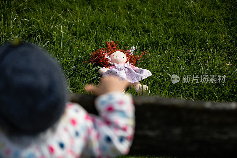 可爱的小女孩在户外玩洋娃娃