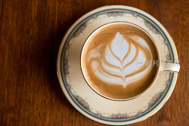 家庭咖啡师-自制纯白咖啡与脱脂牛奶在古董骨瓷杯古董胡桃木桌子