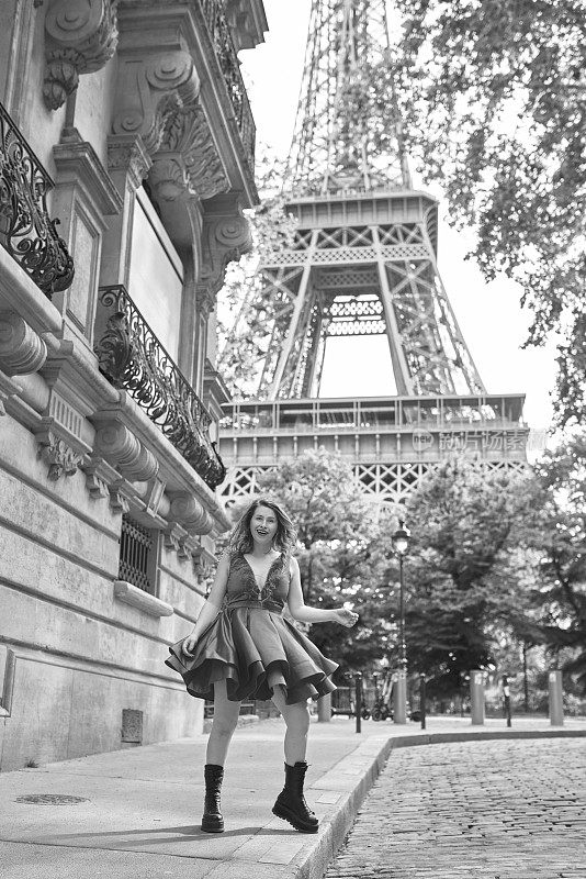 黑白照片，女人在巴黎翩翩起舞，背景是埃菲尔铁塔