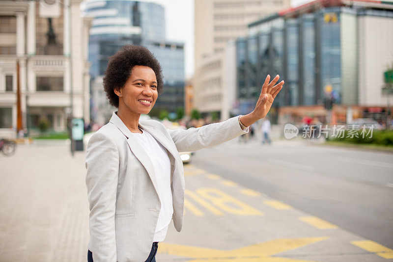 美丽的非裔美国妇女在城市街道上叫出租车