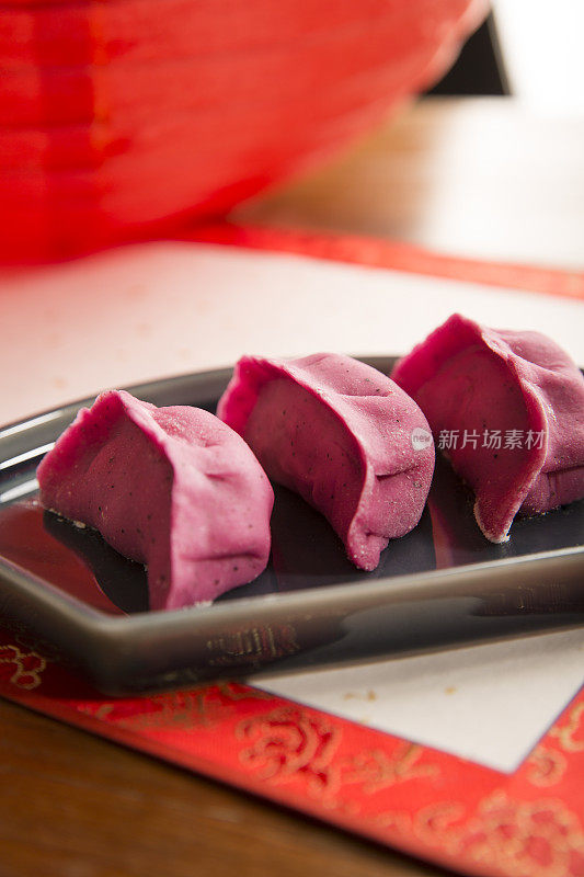 红色的饺子，展开的书法画卷，红色的纸灯笼，中国新年，节日气氛背景