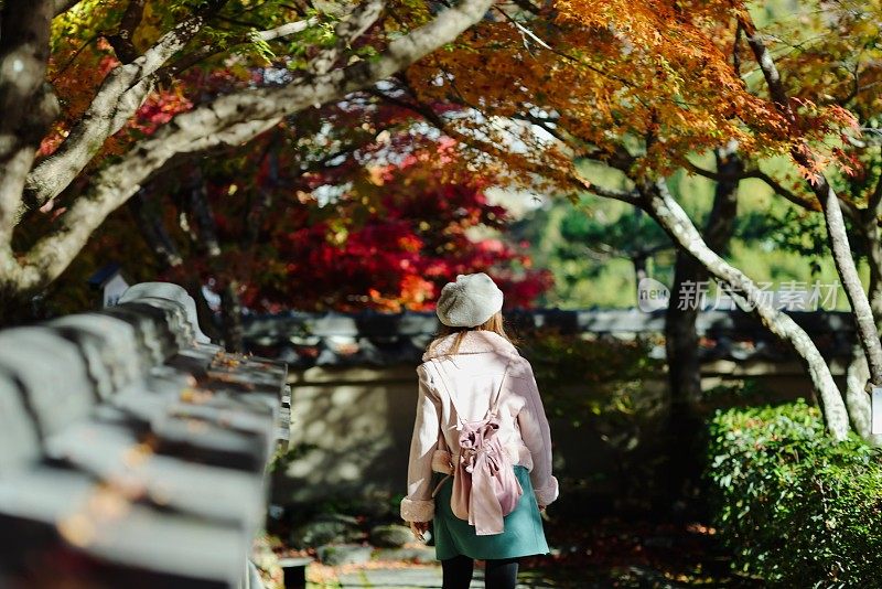 年轻女子享受秋叶