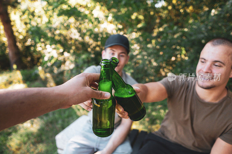 两个男人在大自然中碰杯，欢呼，举杯庆祝