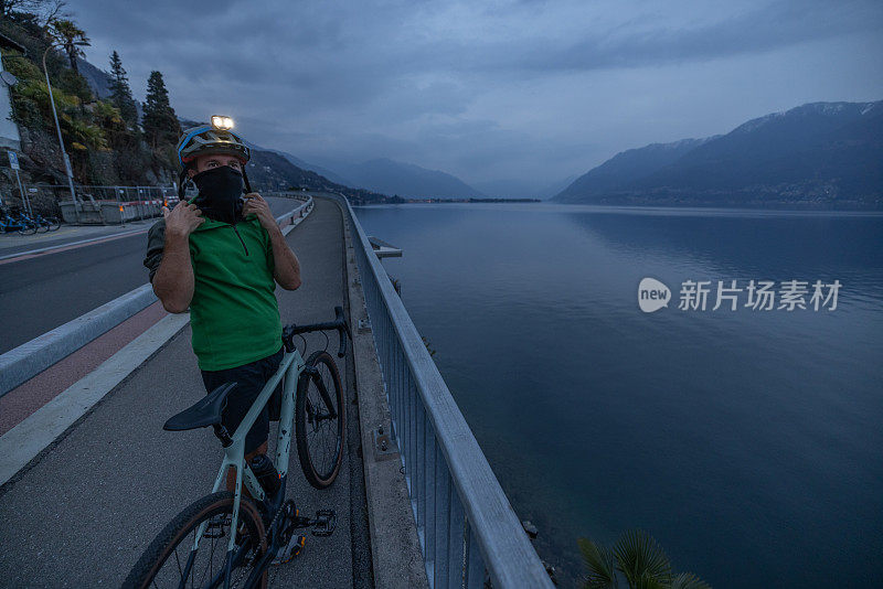 晚上骑自行车训练的男子在自行车道上休息