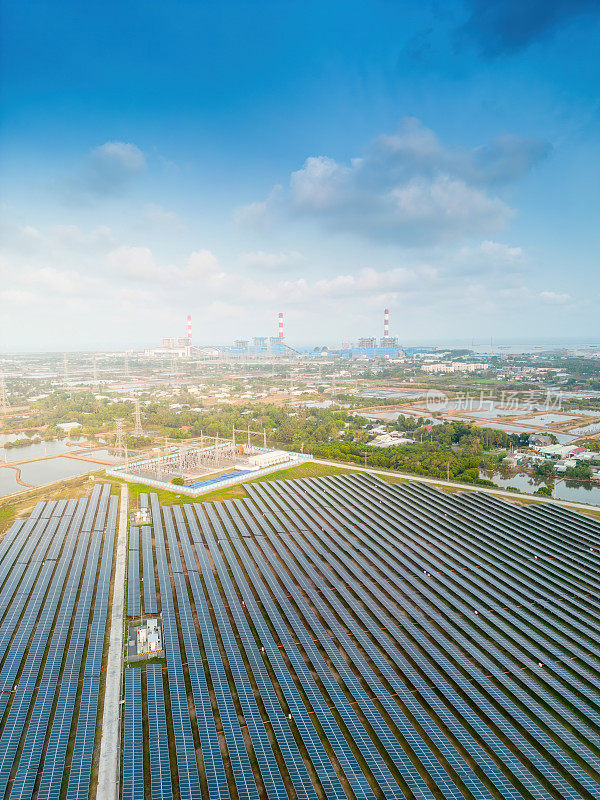 大型可持续发电厂鸟瞰图，有许多排太阳能光伏板，用于在日落天空的农村生产清洁的生态电能