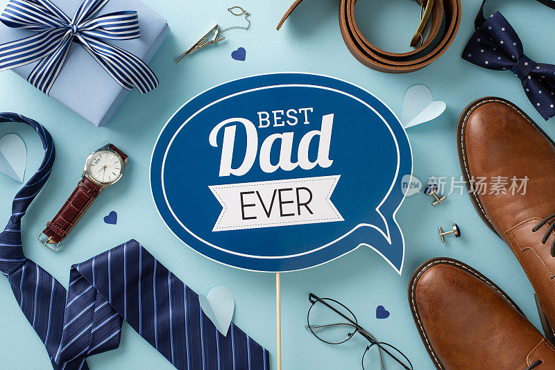 时髦的父亲节概念。蓝色背景的问候牌匾、礼盒、皮鞋、领带、领结、腕表、配饰、腰带、袖扣、眼镜