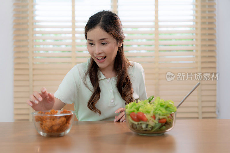 年轻的亚洲女性不吃沙拉，而是选择在客厅吃不健康的快餐——炸鸡。