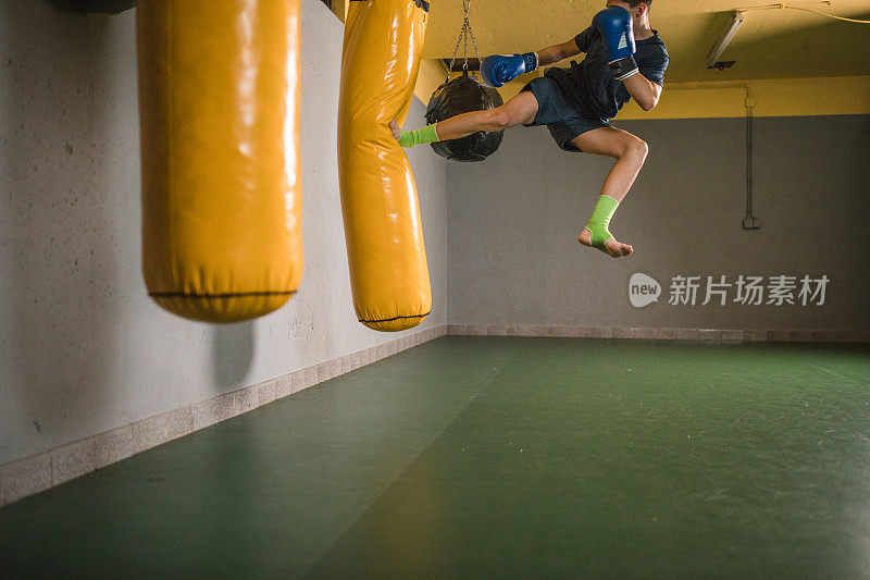 自信的男拳击手在健身房打沙袋