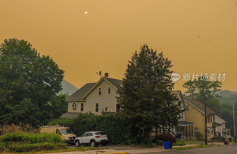 红色薄雾和朦胧天空下的小社区:宾夕法尼亚州波科诺斯阿巴拉契亚山脉吉姆索普街道上的小房子