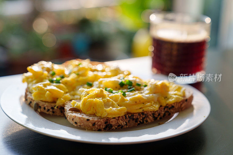 这张特写是松软的黄油炒蛋和一杯黑咖啡，代表一顿健康的早餐