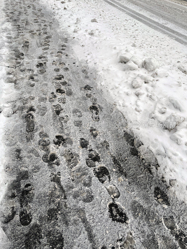 雪地上的轮胎印和人的脚印。