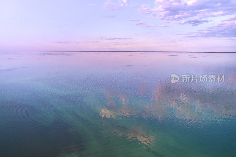 一个湖泊在黄昏时反射出紫色的天空，创造出迷人的自然景观