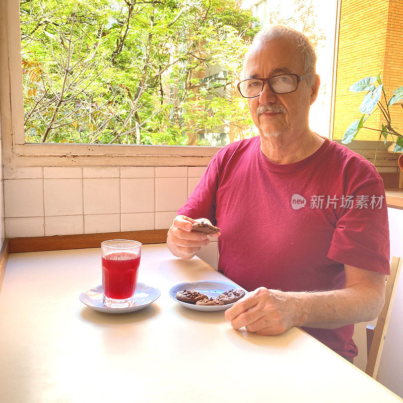 第三个男人在家里的厨房里拿着零食