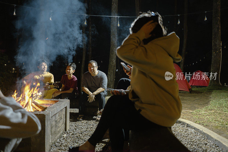 一群朋友在晚上露营时玩吉他