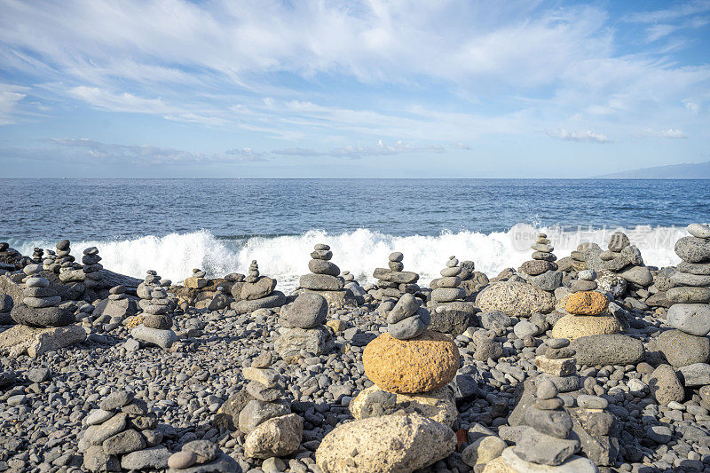 夏天，特内里费岛有多石的海滩，天空晴朗，还有许多旅游丘