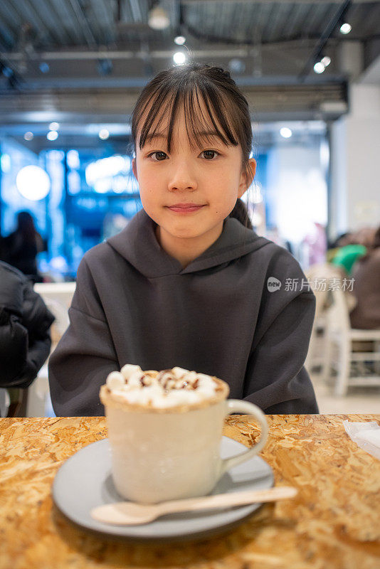 一个十几岁的女孩在咖啡馆拿着一杯咖啡的肖像