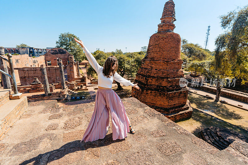 年轻女子在泰国大城府历史公园的Ratchaburana寺跳舞