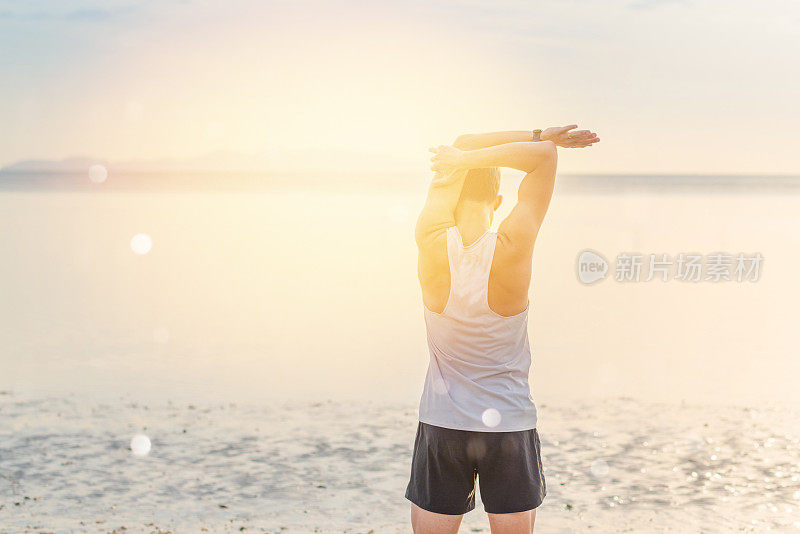 年轻的亚洲男子在日落海滩做瑜伽运动