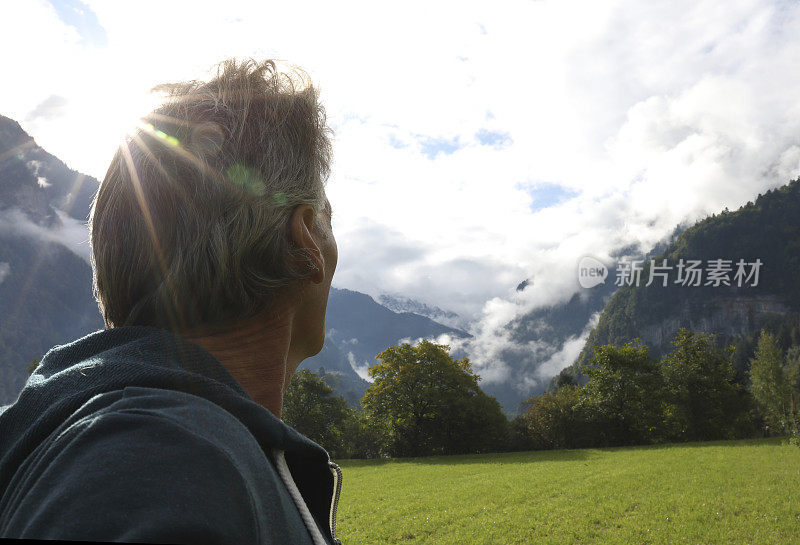 人越过草地望向群山