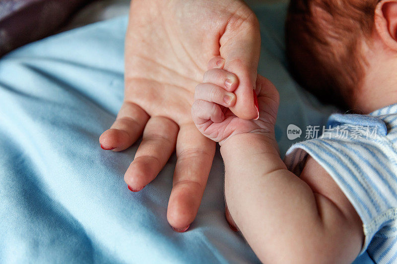 小婴儿牵着妈妈的手