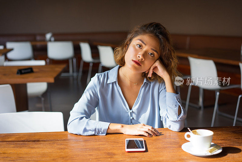 沉思的年轻女商人在她的咖啡休息时间