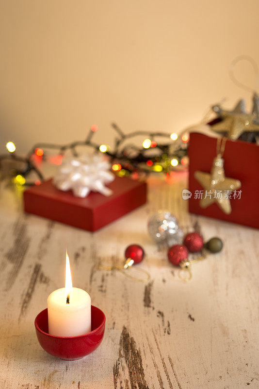 桌上摆着圣诞装饰品和白色蜡烛。