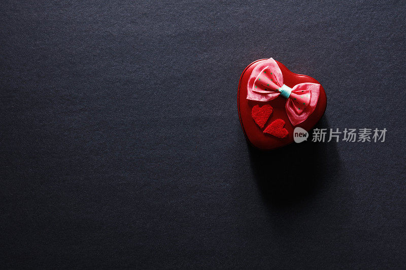 优雅的礼盒与红丝带与蝴蝶结在黑色的背景。