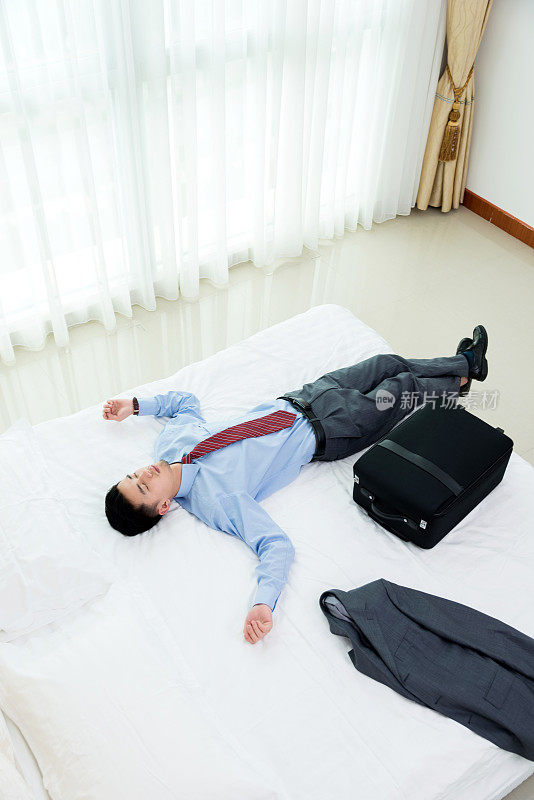 商人躺在床上拿着行李