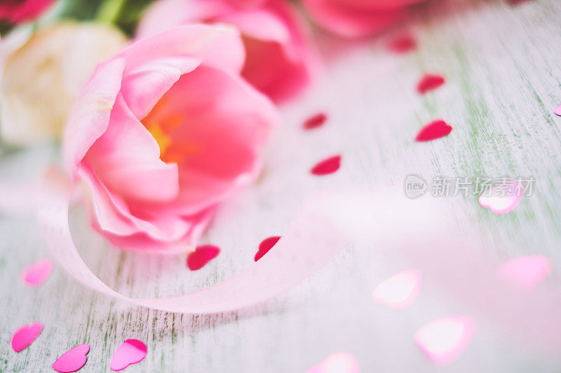 桌上放着粉红色的郁金香，散景，散焦的灯光