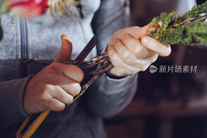 现代花匠工作与鲜花在车间-与手的细节